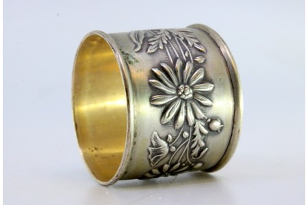Argola de guardanapo pequena em prata com motivos florais relevados.